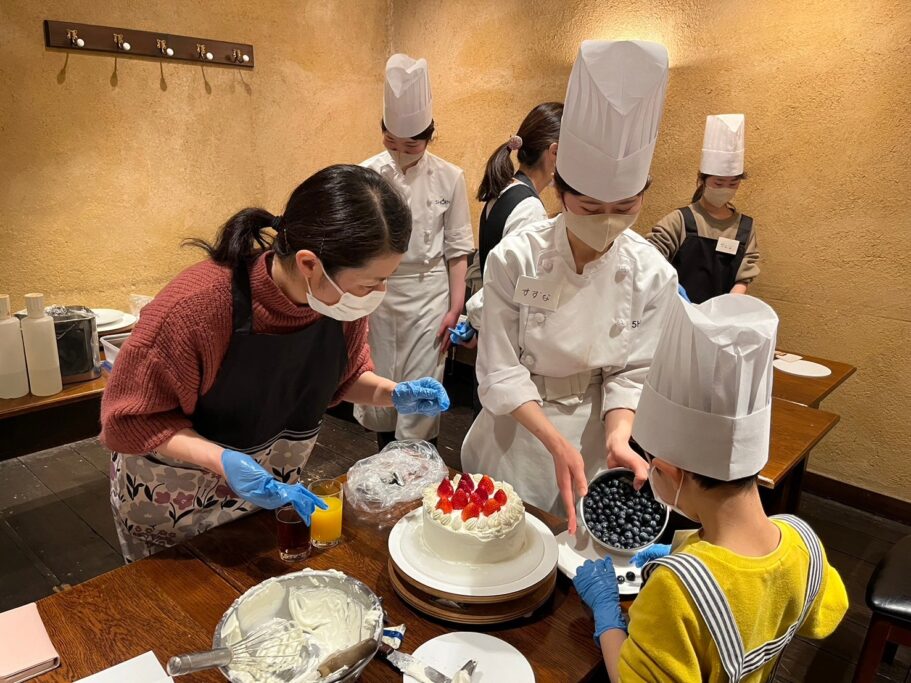 親子パティシエ体験でショートケーキにデコレーションするフルーツを選んでいる様子